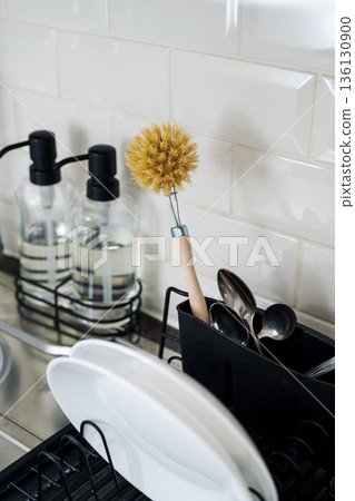 Wooden brush for washing dishes in the kitchen next to sink. Eco friendly, zero waste or conscious consumption concept. Copy space Wooden brush for washing dishes in the kitchen next to sink. Eco friendly, zero waste or conscious consumption concept. Copy space 136130900