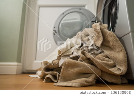 Washing machine with dirty towels on the floor near it. Laundry washer with opened door. Lifestyle. Copy space Washing machine with dirty towels on the floor near it. Laundry washer with opened door. Lifestyle. Copy space 136130908