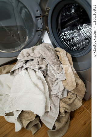 Washing machine with dirty towels on the floor near it. Laundry washer with opened door. Lifestyle. Copy space 136130913