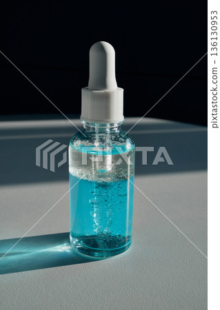 Clear bottle containing blue liquid product Clear bottle containing blue liquid product 136130953