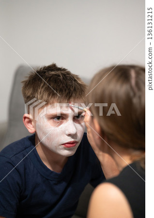 A young person receives face painting, a creative activity often enjoyed during celebrations or special events. 136131215