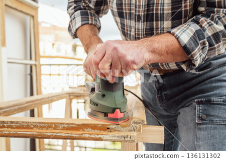 Carpenter at work, restoring an old wooden window. Carpentry. 136131302