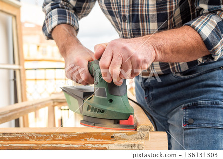 Carpenter at work, restoring an old wooden window. Carpentry. 136131303