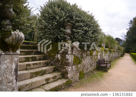 An ancient building in a park in Vigo, northern Italy, with mature trees and spreading branches in spring. concept encompasses tourism, relaxation, sustainable development, urban green spaces. An ancient building in a park in Vigo, northern Italy, with mature trees and spreading branches in spring. concept encompasses tourism, relaxation, sustainable development, urban green spaces. 136131882