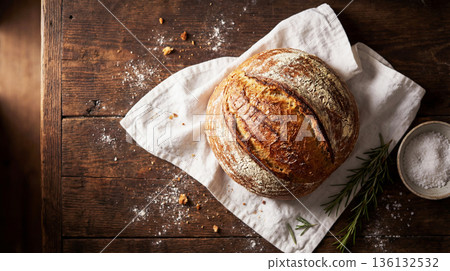 Freshly baked artisan bread, with a golden crust and crispy texture, in a rustic setting 136132532
