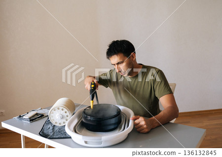 Technician meticulously cleaning filter of air humidifier with steam cleaner, promoting optimal performance and maintaining high standards of hygiene for air quality. Concept of healthy lifestyle. 136132845