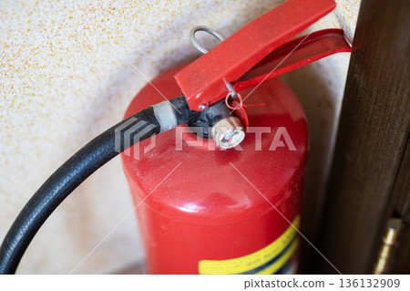 Wallmounted extinguisher with details. Industrial safety equipment showing wear and gauges 136132909