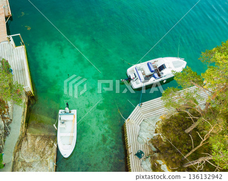 Norwegian hytte and boats on fjord shore, aerial view 136132942