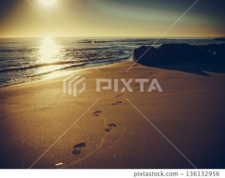 Sunset and footprints on beach Sunset and footprints on beach 136132956