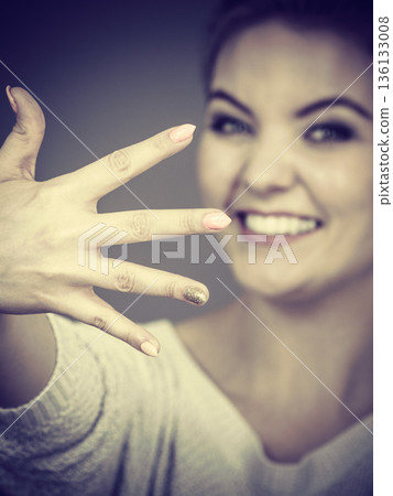 Happy woman showing her hand 136133008