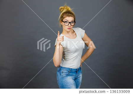 Woman wearing eyeglasses pointing at camera Woman wearing eyeglasses pointing at camera 136133009