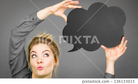 Happy woman holding black thinking bubble Happy woman holding black thinking bubble 136133015