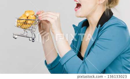 Woman hand holding shopping cart with sweet bun 136133023