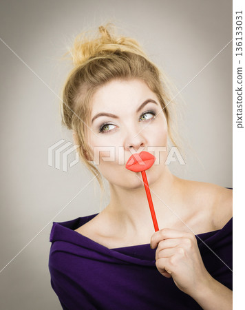 Funny woman holding big red lips on stick 136133031