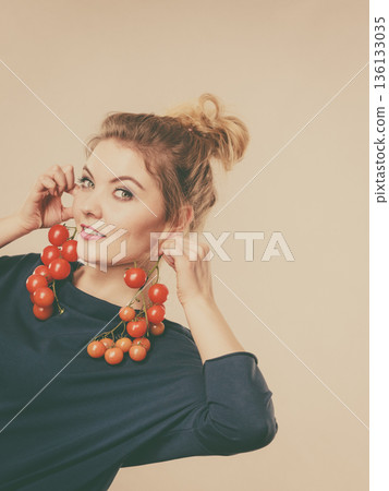 Woman holding fresh cherry tomatoes Woman holding fresh cherry tomatoes 136133035