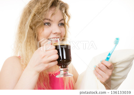 Happy woman holding toothbrush and coffee Happy woman holding toothbrush and coffee 136133039