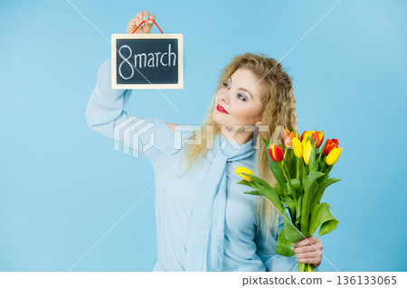 Woman holds tulips, board with text 8 march Woman holds tulips, board with text 8 march 136133065