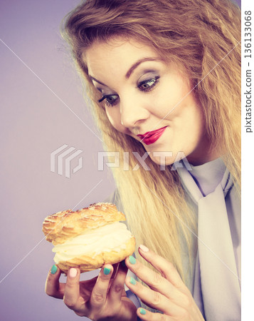Funny woman holds cream puff cake Funny woman holds cream puff cake 136133068