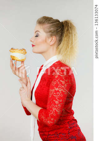 Happy woman holding choux puff cake Happy woman holding choux puff cake 136133074