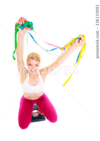 Joyful woman on weighing scale. Slimming diet. 136133091