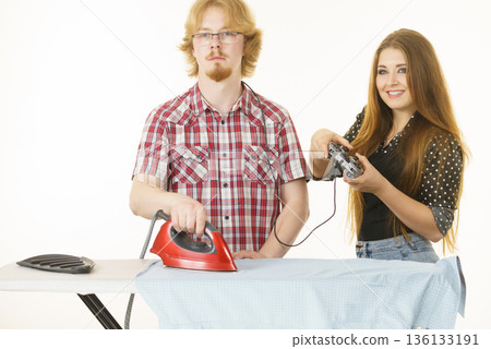 Woman controling man to do ironing Woman controling man to do ironing 136133191