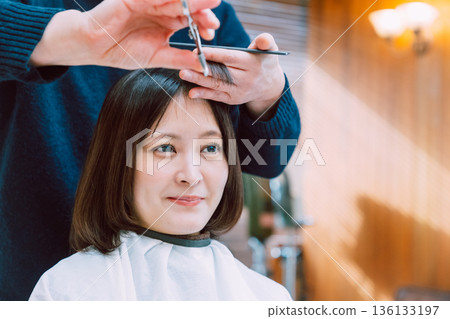 Woman cutting hair at beauty salon 136133197