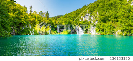 View of waterfall at Plitvice lakes, Croatia. Panoramic view of fresh nature, blue water and green trees. 136133330
