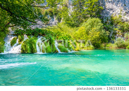 View of waterfall at Plitvice lakes, Croatia. Panoramic view of fresh nature, blue water and green trees. 136133331