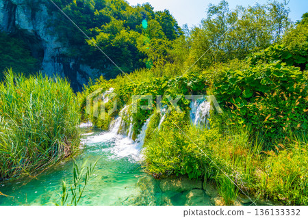 View of waterfall at Plitvice lakes, Croatia. Panoramic view of fresh nature, blue water and green trees. 136133332