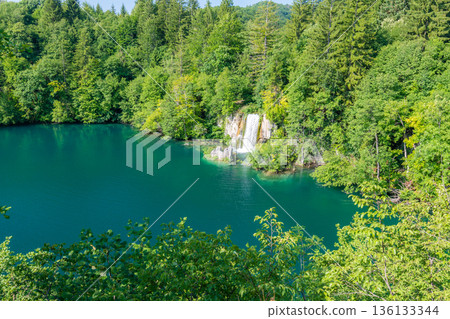 View of waterfall at Plitvice lakes, Croatia. Panoramic view of fresh nature, blue water and green trees. 136133344