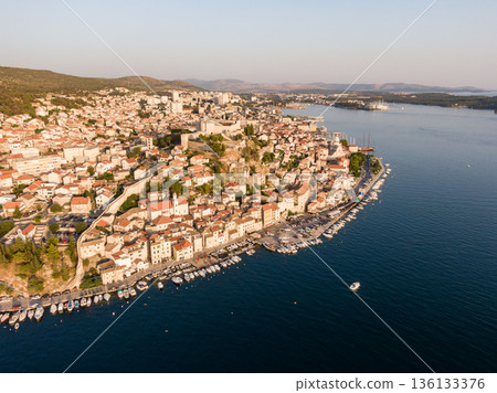 Aerial dronw view of sunset over the Sibenik city, Croatia. Ancient and old town coastline with harbor near the sea. Fortress above the city. Famous tourist destination in Croatia. 136133376