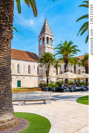 The Church of St Dominic, Trogir - Croatia. Beautiful view of ancient building, palm trees and the restaurant near. Summer weather. The Church of St Dominic, Trogir - Croatia. Beautiful view of ancient building, palm trees and the restaurant near. Summer weather. 136133384
