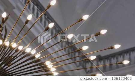 Chandelier lighting up interior space with decorative brass bulbs creating ambiance Chandelier lighting up interior space with decorative brass bulbs creating ambiance 136133403