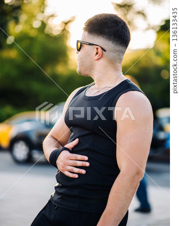 Man in black tank top and sunglasses looking left during sunset outdoor Man in black tank top and sunglasses looking left during sunset outdoor 136133435