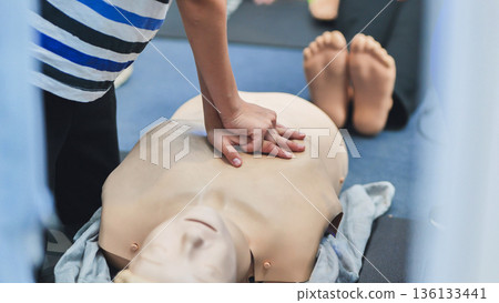 Hands performing chest compressions on a medical training mannequin for life saving skills Hands performing chest compressions on a medical training mannequin for life saving skills 136133441