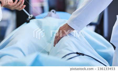 Surgical team performing a delicate laparoscopic procedure on a patient in hospital Surgical team performing a delicate laparoscopic procedure on a patient in hospital 136133453