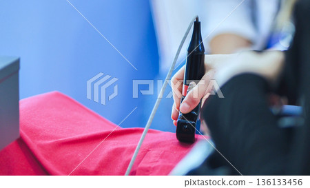 Attending medical forum, a person holding an ultrasound transducer for training Attending medical forum, a person holding an ultrasound transducer for training 136133456
