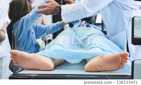 Medical student practicing procedure on a simulation mannequin in a training environment Medical student practicing procedure on a simulation mannequin in a training environment 136133472