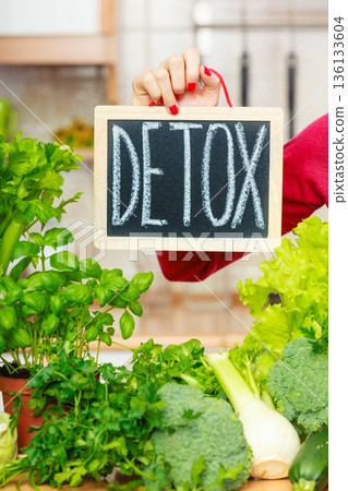 Woman having green diet vegetables, detox sign 136133604