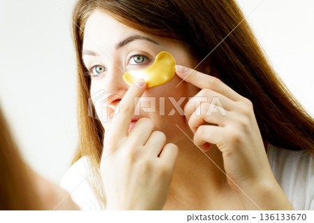 Woman with gold patches under eyes 136133670