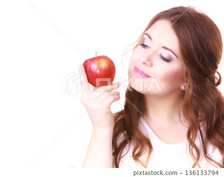 Woman holding apple fruit close to face Woman holding apple fruit close to face 136133794