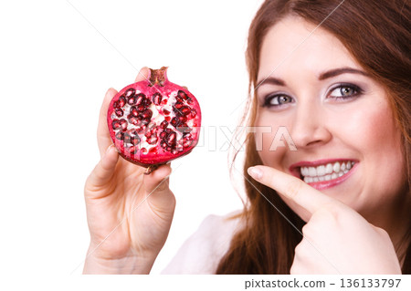 Cheerful woman holds pomegranate fruits, isolated 136133797