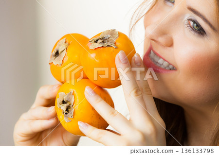 Woman holds persimmon kaki fruits 136133798