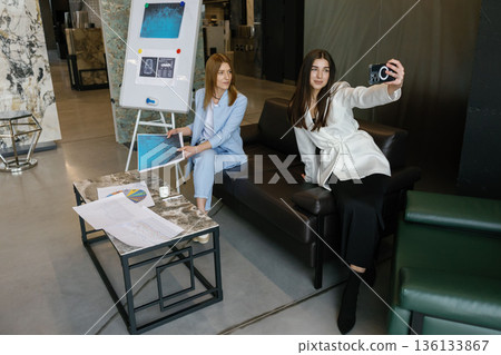 Businesswomen posing for selfie during creative agency collaboration 136133867