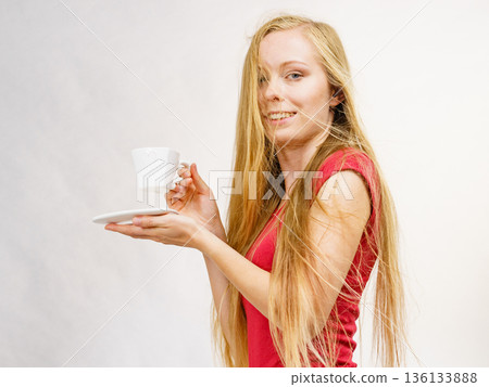 Blonde girl blowing hair holds coffee cup Blonde girl blowing hair holds coffee cup 136133888