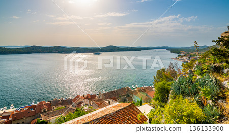 Coastal view of Sibenik old city, Croatia. Cathedral of St James, adriatic sea with island in background. Summer weather, aerial view of city roofs. UNESCO heritage. 136133900