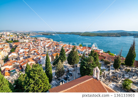 Coastal view of Sibenik old city, Croatia. Cathedral of St James, adriatic sea with island in background. Summer weather, aerial view of city roofs. UNESCO heritage. Coastal view of Sibenik old city, Croatia. Cathedral of St James, adriatic sea with island in background. Summer weather, aerial view of city roofs. UNESCO heritage. 136133903
