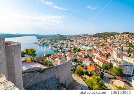 Coastal view of Sibenik old city, Croatia. Cathedral of St James, adriatic sea with island in background. Summer weather, aerial view of city roofs. UNESCO heritage. Coastal view of Sibenik old city, Croatia. Cathedral of St James, adriatic sea with island in background. Summer weather, aerial view of city roofs. UNESCO heritage. 136133905