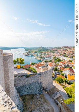 Coastal view of Sibenik old city, Croatia. Cathedral of St James, adriatic sea with island in background. Summer weather, aerial view of city roofs. UNESCO heritage. Coastal view of Sibenik old city, Croatia. Cathedral of St James, adriatic sea with island in background. Summer weather, aerial view of city roofs. UNESCO heritage. 136133906
