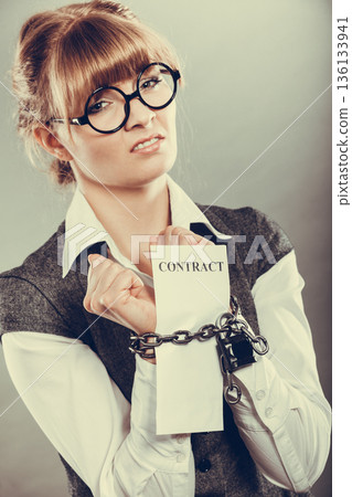 businesswoman with chained hands holding contract businesswoman with chained hands holding contract 136133941